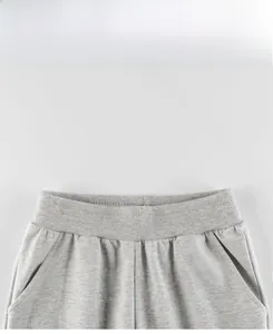 Detail of light gray kids jogger pants showing elastic waistband and reinforced stitching
