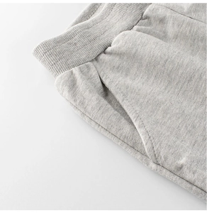 Detail of grey knitted kids sports pants showing elastic waistband and side pocket stitching
