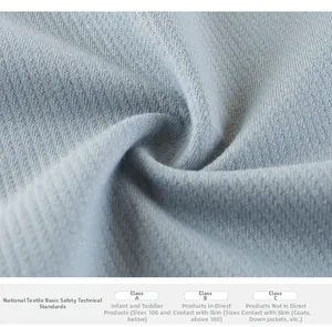 Close-up of soft light blue waffle knit fabric and textile safety standards label