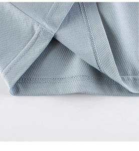 Detail view of double-stitched hem on light blue cotton t-shirt showing fabric texture