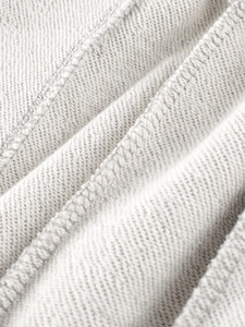 Gros plan du tissu éponge gris clair et des coutures renforcées du pantalon garçon
