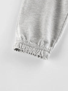 Close-up of grey knit joggers for boys featuring ribbed elastic cuffs and stitching
