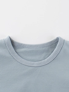 Close-up of crew neck detailing on a light blue-grey kids knitted long sleeve T-shirt