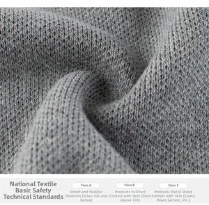 Macro view of gray knit fabric showing ribbed texture and safety standard labels