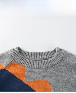 Detail of the ribbed crewneck and geometric color-block knit on this boy dinosaur sweater