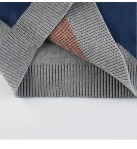 Close-up of the ribbed hem and knit texture on children's dinosaur sweater