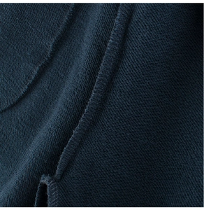Detailed macro view of dark blue loopback cotton fabric and precise overlock stitching