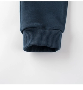 Detailed close-up of dark blue ribbed cuffs on boys' knitted cotton dinosaur pants