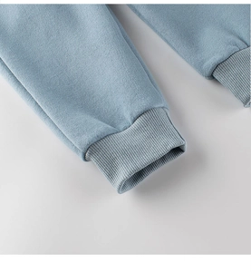 Gros plan des poignets côtelés et du tissu en maille douce du pantalon de sport bleu