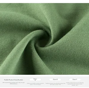 Detail of soft grass green knitted fabric with safe textile classification text