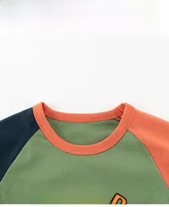 Close-up of the ribbed crew neck and colorful PLEASED letter print on a toddler tee