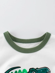 Détail du col côtelé vert et du motif dinosaure sur ce t-shirt blanc pour enfants en coton