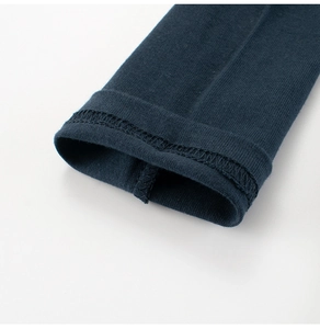 Dettaglio del polsino blu navy con cucitura a doppio ago su tessuto di cotone
