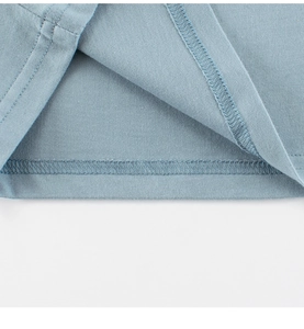 Detailed view of the double-stitched hem on the blue-grey cotton knit long sleeve T-shirt