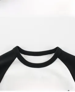 Close-up of the round neckline and TRAVEL print on this black and white raglan kids T-shirt