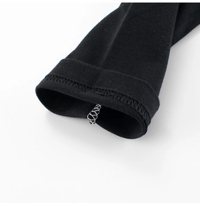 Close-up of overlock stitching on the sleeve cuff of a black knitted kids long sleeve t-shirt
