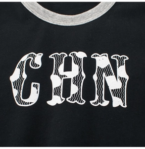 Détail du col gris côtelé et de l'imprimé CHN sur le t-shirt noir en coton pour enfants