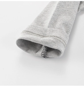 Détail du poignet en maille gris chiné avec finitions soignées en couture double aiguille