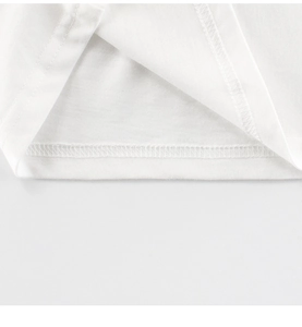 Détail de la couture double aiguille sur l'ourlet d'un t-shirt blanc en coton pour enfants
