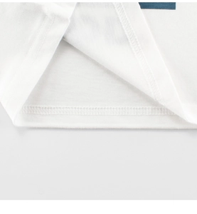 Détail de l'ourlet d'un t-shirt blanc avec double surpiqûre et coutures intérieures soignées