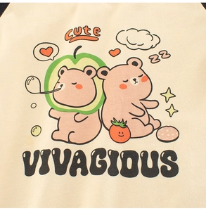 Détail de l'imprimé ours de dessin animé sur le t-shirt beige à manches longues bébé
