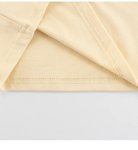 Détail du tissu en coton crème de qualité avec coutures doubles lisses sur l'ourlet bas