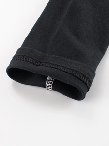 Détail de la manchette de manche raglan en maille noire avec couture à double aiguille