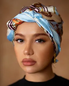 Detail of luxury silk-like scarf featuring golden chain patterns and elegant blue tones