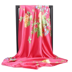 Detail of satin floral hijab showing glossy fuchsia fabric with yellow rose print texture