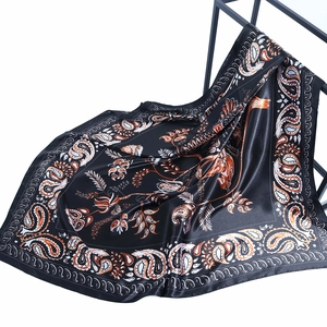 Detalle de pañuelo de satén paisley con textura sedosa y patrones de flores de anacardo