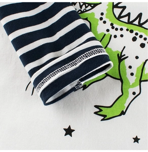 Detail of children's long-sleeve dinosaur shirt with navy striped cuffs and neat stitching