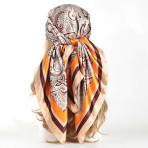 90cm paisley satin square scarf in orange and brown tones worn as a stylish headscarf