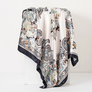 Detail of vintage paisley and floral print silk scarf draped on a white display stand