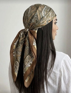 Detail of vintage paisley print silk scarf in brown, shown as a retro bohemian headwrap