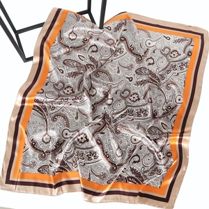 Champagne gold paisley 90cm square silk satin scarf hanging on black geometric stand