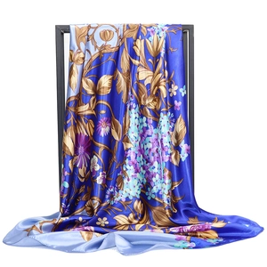 Detail showing high-gloss satin silk scarf with intricate blue floral patterns