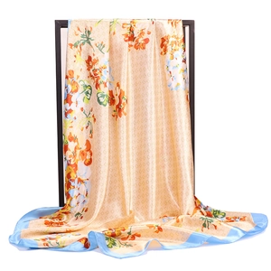 Macro detail of satin floral silk scarf featuring signature double G monogram pattern