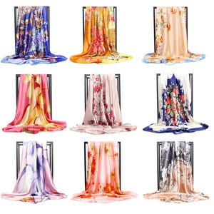 Nine assorted 90cm satin silk scarves with floral prints displayed on black racks