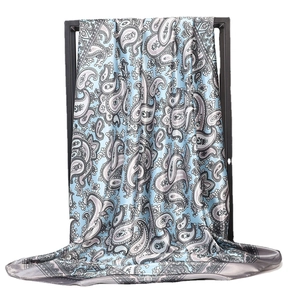 Blue paisley print satin silk scarf with grey border draped on a black stand