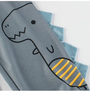 Gros plan d'un pantalon gris pour enfant avec nageoires de dinosaure 3D et tissu doux