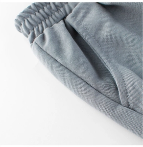 Gros plan détaillé de la taille élastique et des poches sur ce pantalon gris d'été