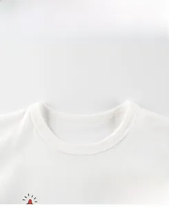 Close-up of the ribbed crew neck and soft cotton fabric on a white kids' graphic T-shirt