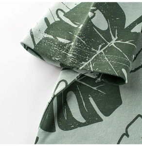 Macro view of high-quality cotton knit fabric with tropical green palm leaf patterns