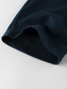 Détail de short en maille bleu marine pour enfant avec ourlet robuste et tissu doux
