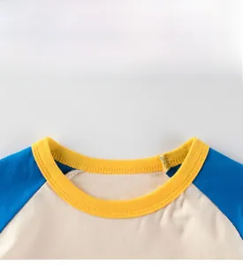 Détail du col côtelé jaune et des manches raglan bleues sur le t-shirt en coton
