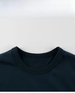 Détail du col à double surpiqûre sur un t-shirt en coton bleu foncé pour garçons