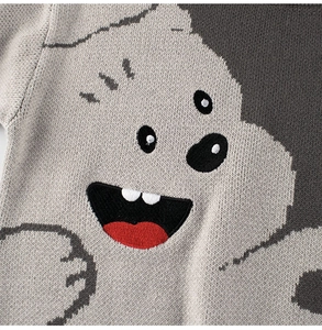 Dettaglio del maglione in maglia grigia con un simpatico motivo a mostro animato