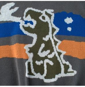 Detail of a dark grey knitted sweater with a colorful dinosaur jacquard pattern