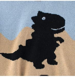 Detail showing high-quality knit texture with a cartoon dinosaur pattern and color blocking
