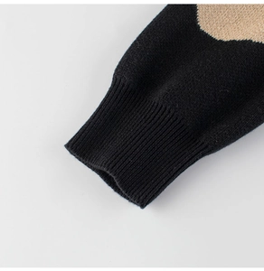 Detail of ribbed cuffs on children's black knitted sweater with color block patterns